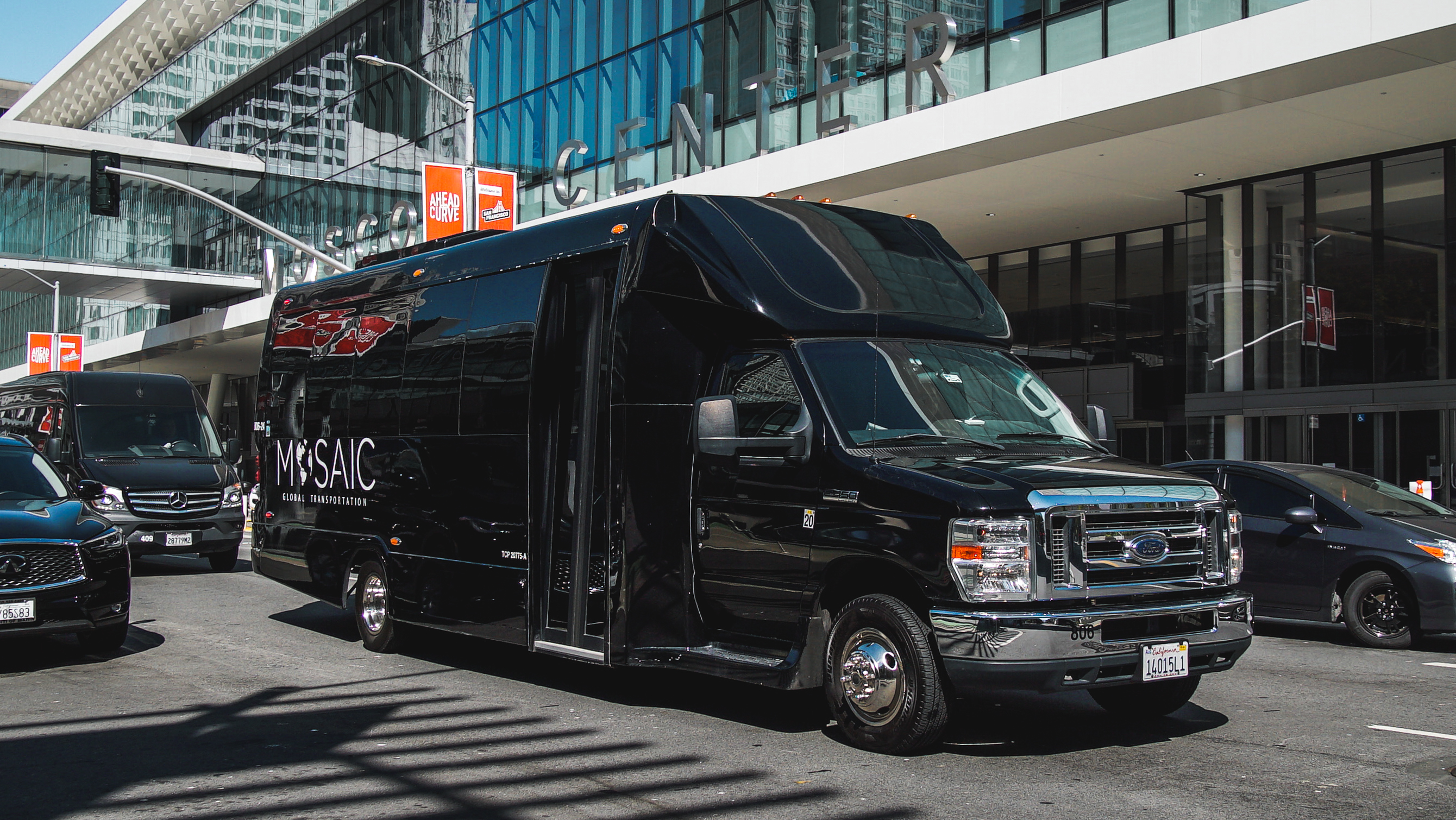 Black luxury vehicle in front of corporate building