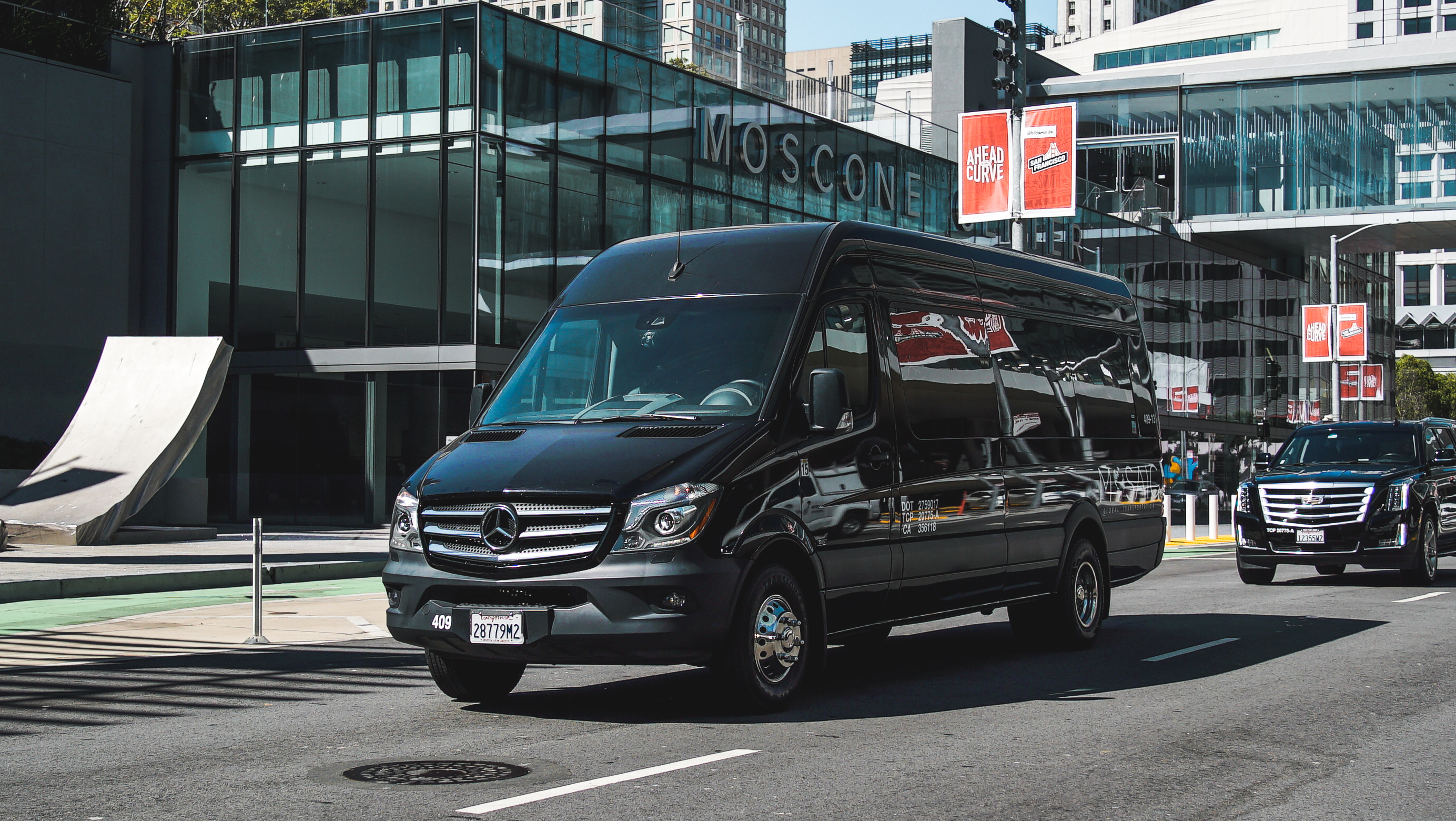 Black luxury shuttle driving down the street