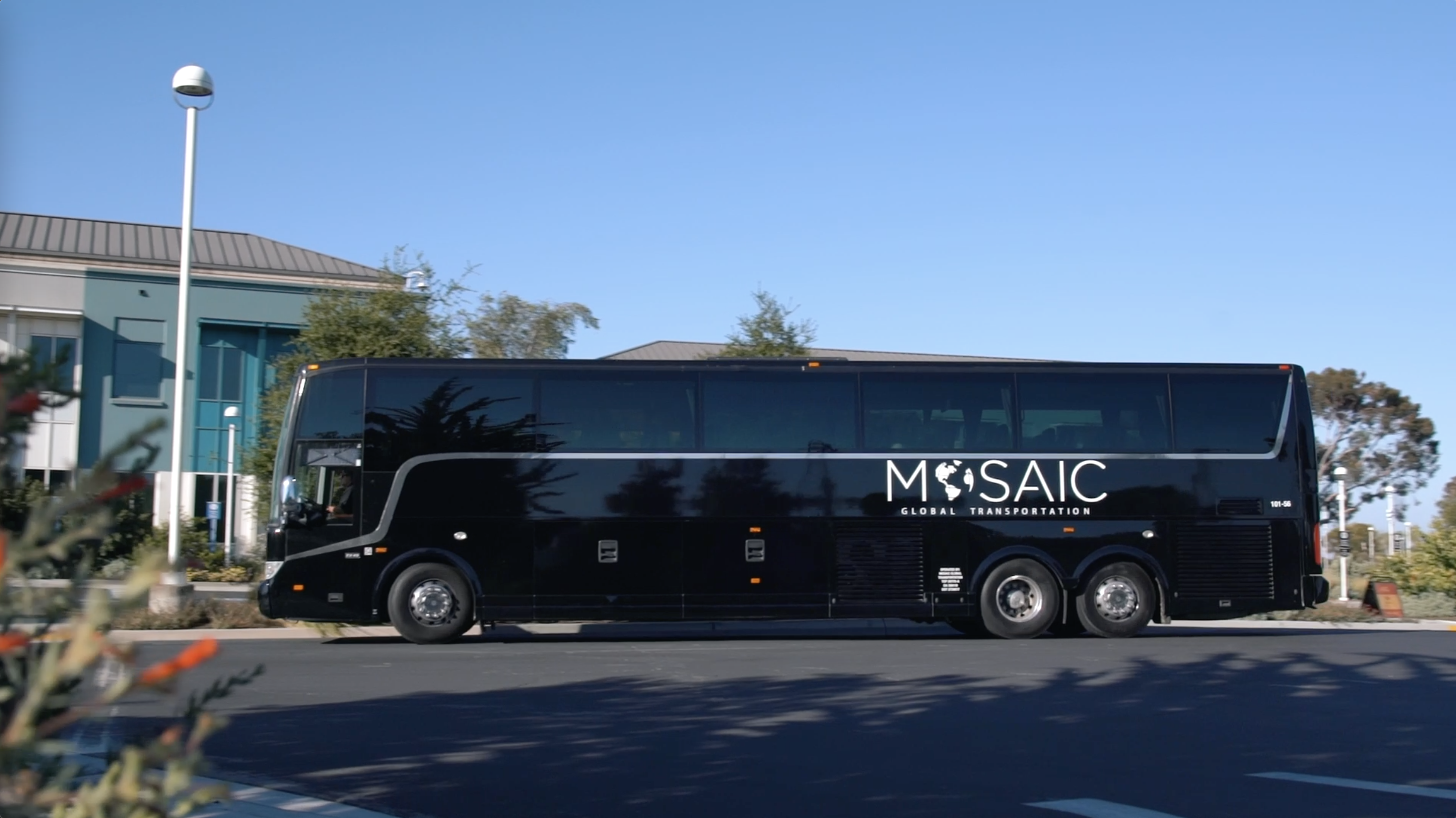 Large black shuttle bus parked on street